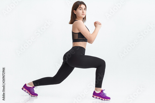 Young brunette woman exercising for weight loss in a gym.