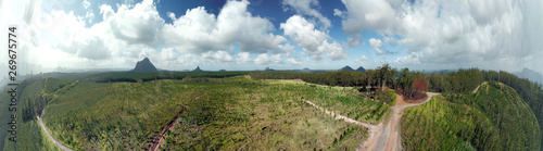 Panoramic aerial view of Glass House Mountains National Park on Sunshine Coast  Queensland  Australia . The Glasshouse Mountains are silhouetted in the afternoon sunlight.