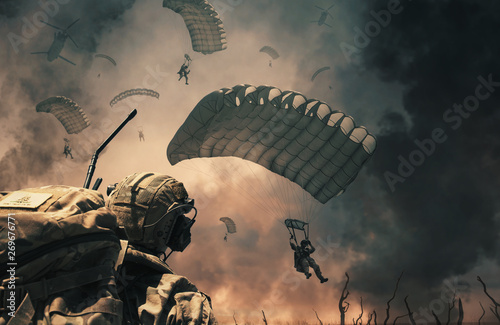 Military helicopter and forces between fire and smoke in destroyed city and soldiers are in flight with a parachute to reach battlefield/A soldier looks at them. photo