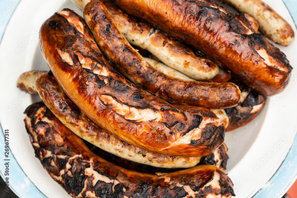 grilled sausages on the grill in the plate. top view grilled sausages on the grill in the plate. top view