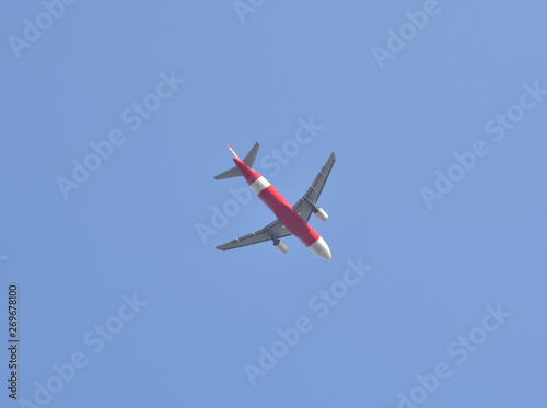 Airplane flying away to the blue sky