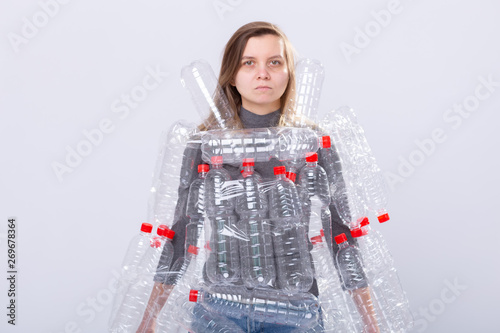Environmental Protection  people and recyclable plastic concept - exhausted woman concerned with environment disaster with dress as plastic bottles on white background