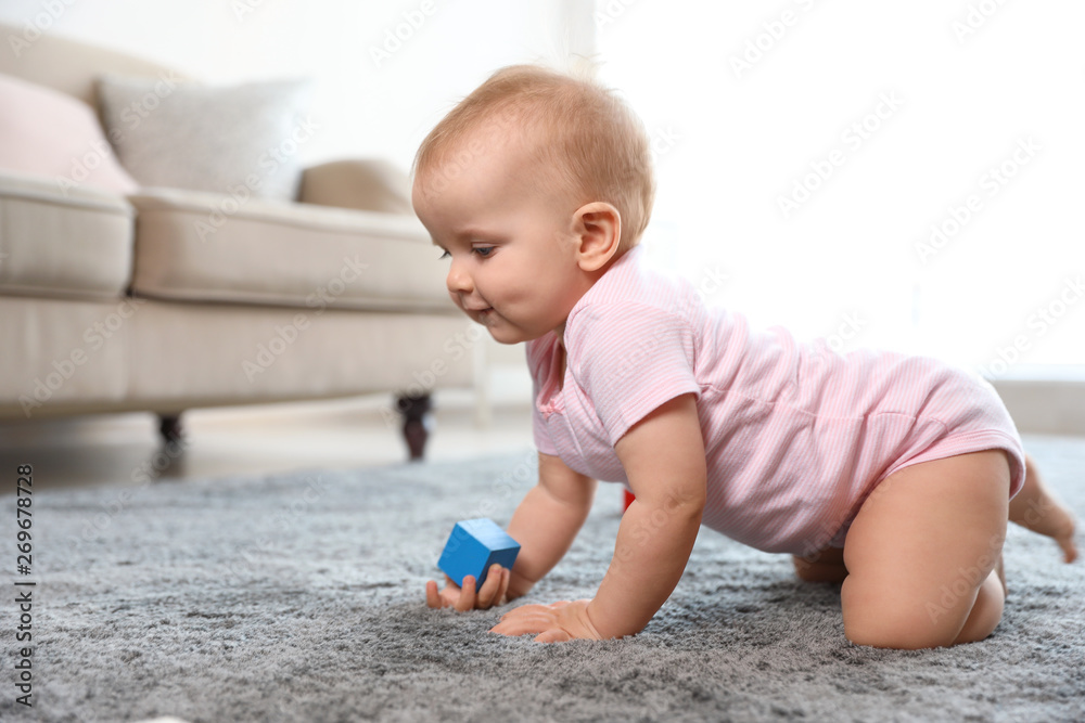 Fototapeta premium Cute baby girl playing on floor in room. Space for text