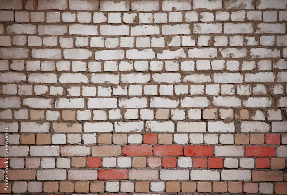 Fototapeta premium Wall of white and red bricks with uneven old masonry