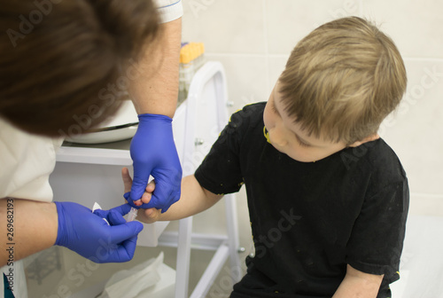 the process of drawing blood from a finger for analysis in a boy photo