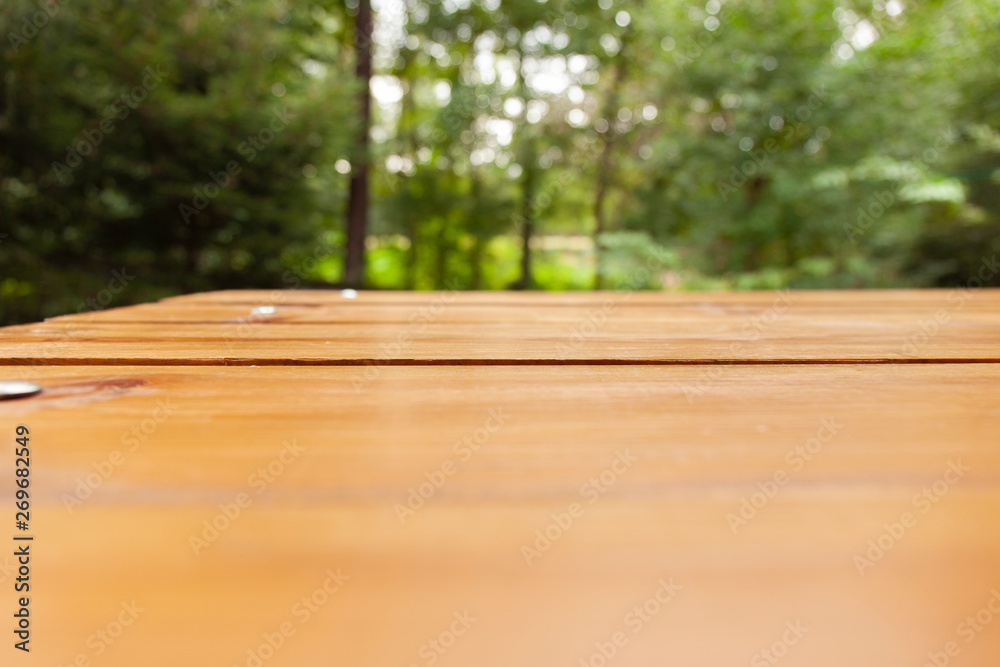 wood plank table with trees in background wood plank table with trees in background