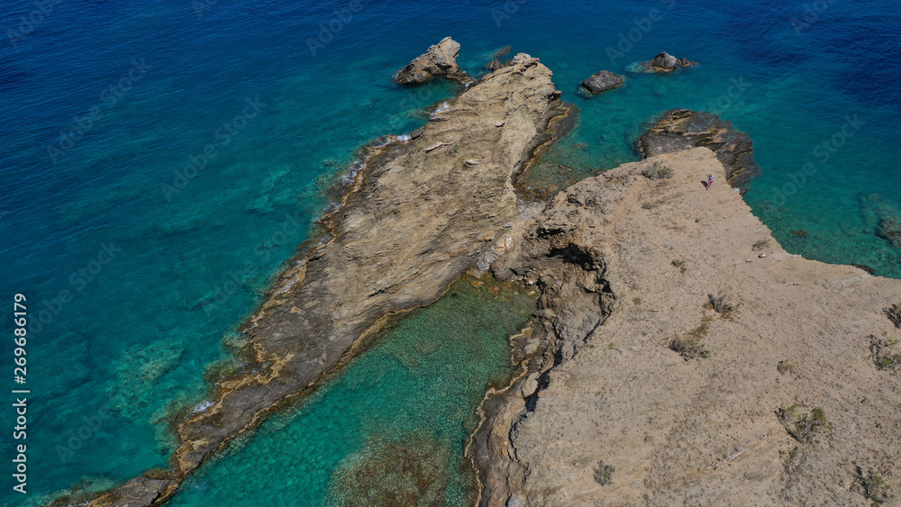Aerial drone photo of iconic deep turquoise beach of Latinaki with crystal clear sea and rocky sea shore forming small caves, Folegandros island, Cyclades, Greece Aerial drone photo of iconic deep turquoise beach of Latinaki with crystal clear sea and rocky sea shore forming small caves, Folegandros island, Cyclades, Greece