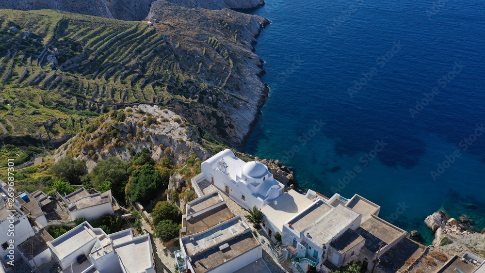 Aerial drone photo of picturesque main village (chora) of Folegandros island built on top of steep hill overlooking the Aegean sea at sunset, Cyclades, Greece