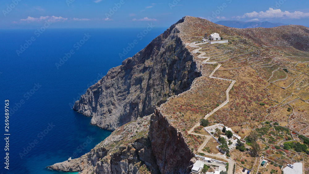 Naklejka premium Aerial drone photo of iconic and picturesque main village (chora) of Folegandros island featuring castle and built on top of steep hill overlooking the Aegean blue sea, Cyclades, Greece