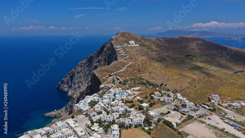 Aerial drone photo of iconic and picturesque main village (chora) of Folegandros island featuring castle and built on top of steep hill overlooking the Aegean blue sea, Cyclades, Greece