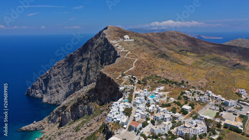 Aerial drone photo of iconic and picturesque main village (chora) of Folegandros island featuring castle and built on top of steep hill overlooking the Aegean blue sea, Cyclades, Greece © aerial-drone