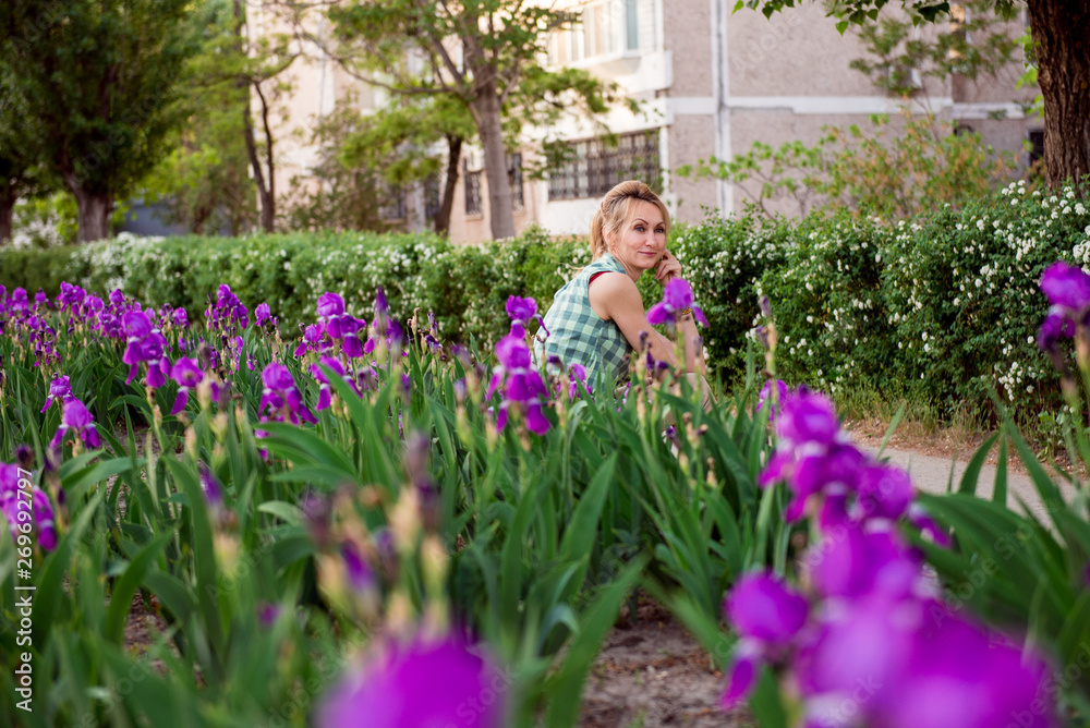 woman in spring. Portrait of a girl in a blooming garden.  woman is walking in the summer in the park. Happy middle-aged woman