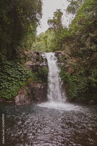 Fototapeta Naklejka Na Ścianę i Meble -  The waterfall is a popular tourist destination in Bali, known for its surrounding attractive foliage
