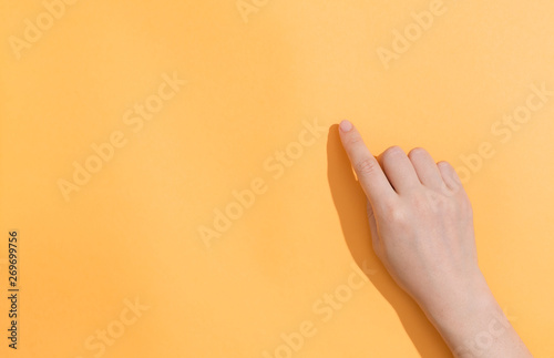 Person pointing to something on a orange background photo