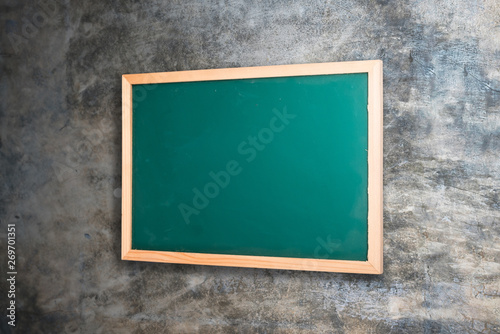 Green blackboard on old wall background 