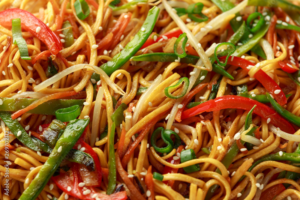 Chow mein, noodles and vegetables dish with wooden chopsticks Chow mein, noodles and vegetables dish with wooden chopsticks