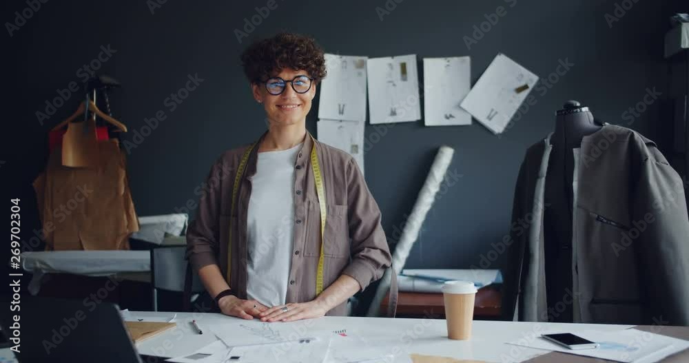 Portrait of successful fashion designer beautiful young woman in workshop looking at camera and smiling. Small business, profession and modern entrepreneurs concept.