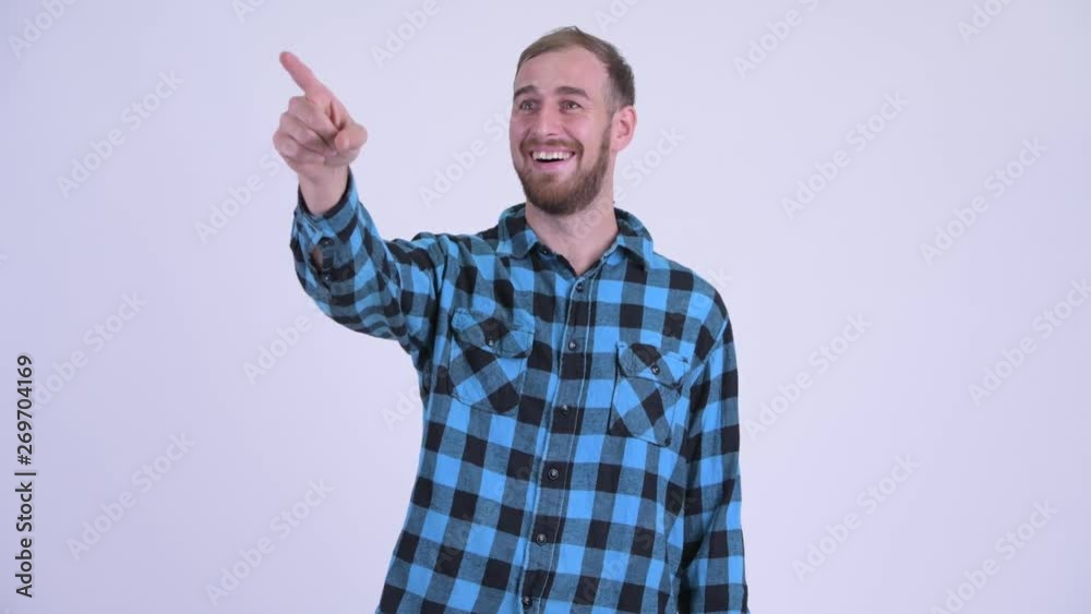 Happy bearded hipster man pointing finger and looking surprised Happy bearded hipster man pointing finger and looking surprised
