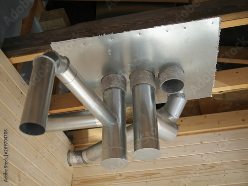 Whole house air ventilation and cleaning system. Ventilation metal pipes in silver insulation material and roof ferm.