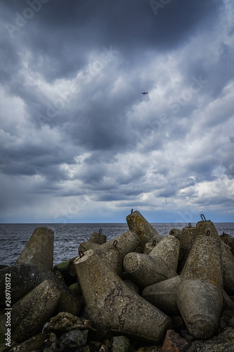 breakwaters on the background of the sea and the cloudy sky