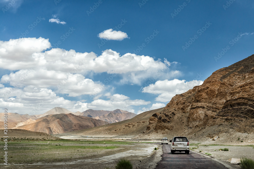 Traveling by van in the city of Leh ladakh, there is a mountain surrounded and arid on a clear day, cloudy In the summer In india.