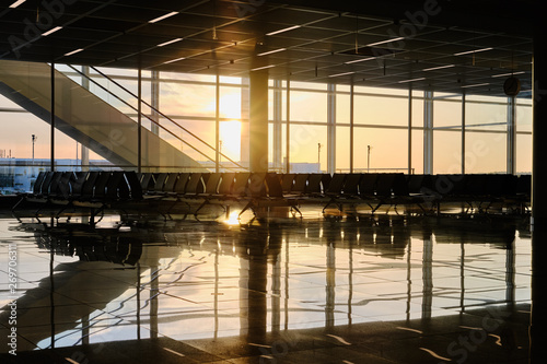 Golden sunset light shining through big windows on empty airport waiting room