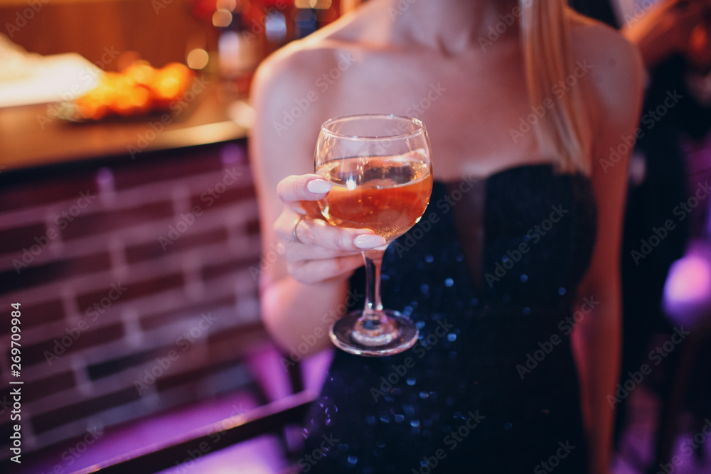 Girl woman holding a champagne glass in her hand at a party