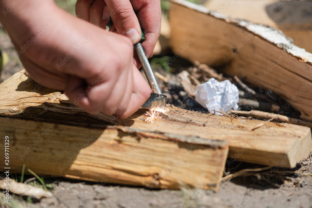 A pair of hands making a fire with flint and steel A pair of hands making a fire with flint and steel