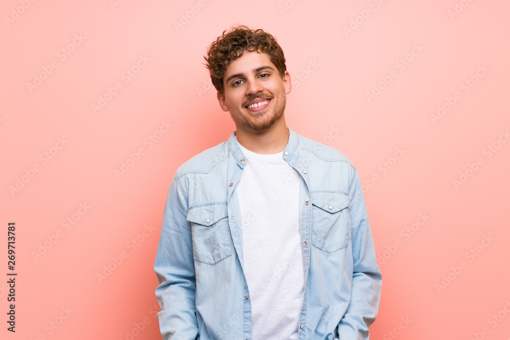 Fototapeta premium Blonde man over pink wall With happy expression