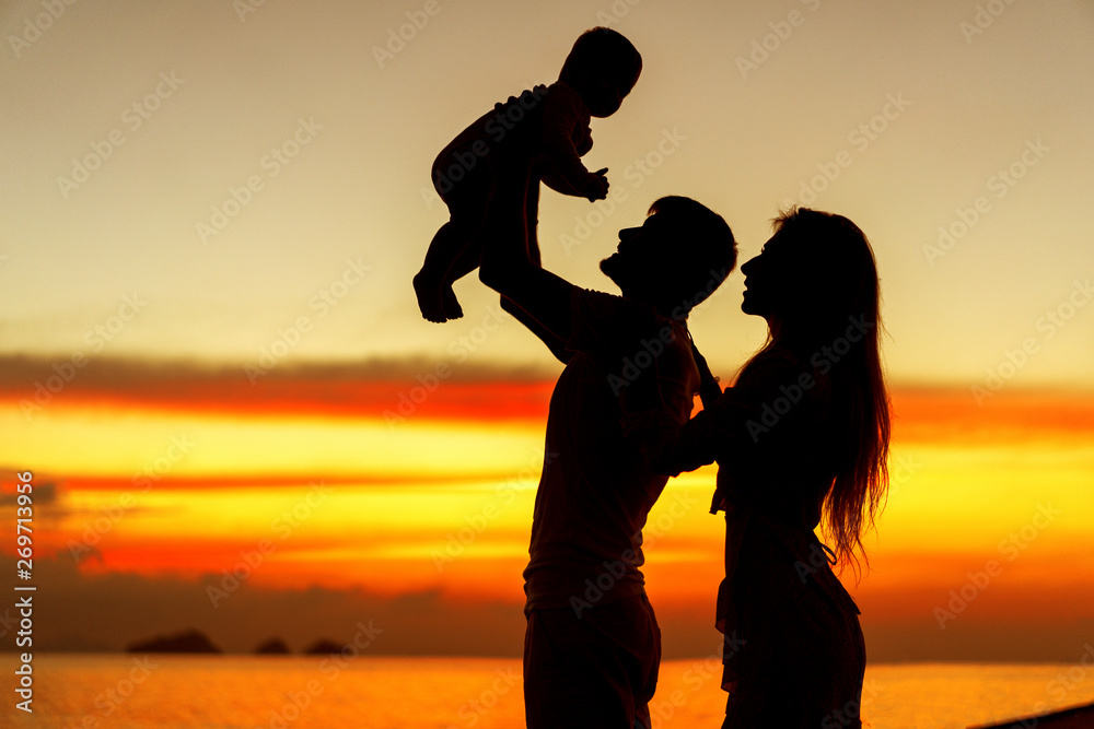 .Family in love with son hugging at sunset, silhouette