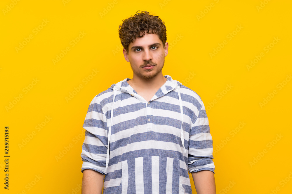 Blonde man over yellow wall portrait Blonde man over yellow wall portrait
