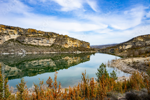 Blue river between two shores. Grey and yellow beautiful mountain cliff in a natural park congost de Mont-rebei Monrebey in Spain. Blue sky and mountains reflecting gorge. photo