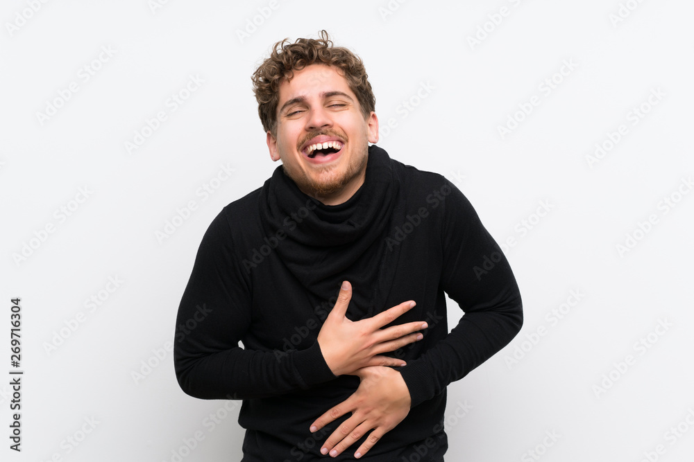Blonde man over isolated white wall smiling a lot Blonde man over isolated white wall smiling a lot