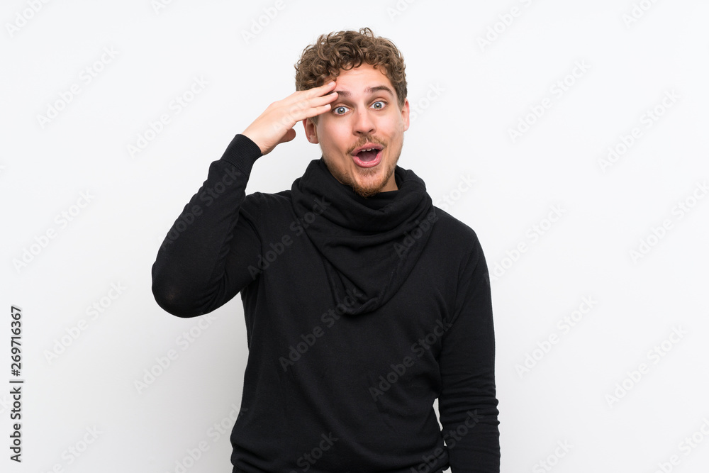 Blonde man over isolated white wall has just realized something and has intending the solution Blonde man over isolated white wall has just realized something and has intending the solution