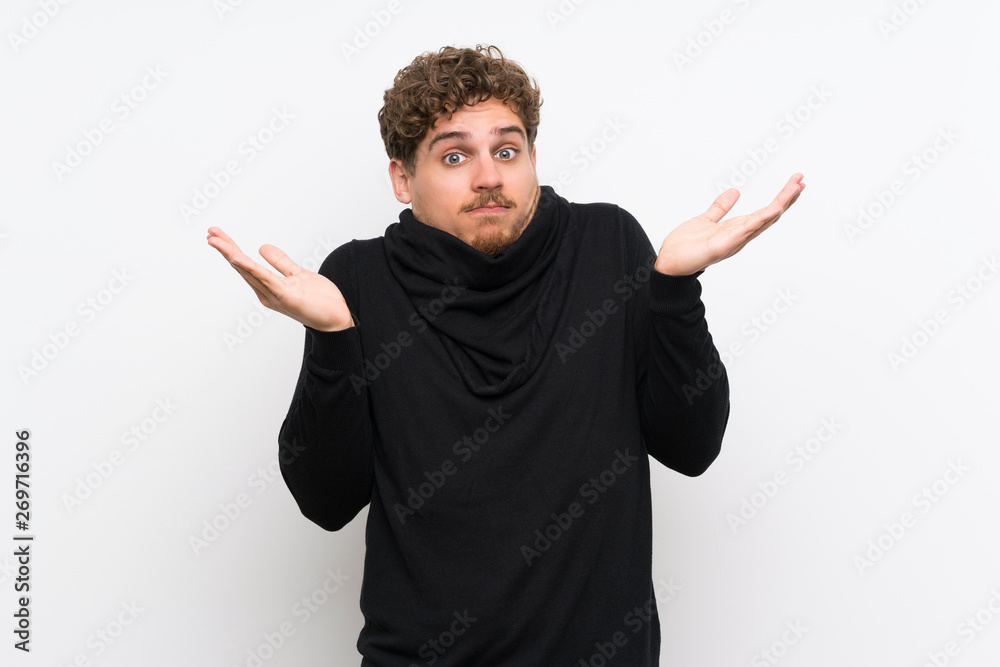 Blonde man over isolated white wall making doubts gesture Blonde man over isolated white wall making doubts gesture