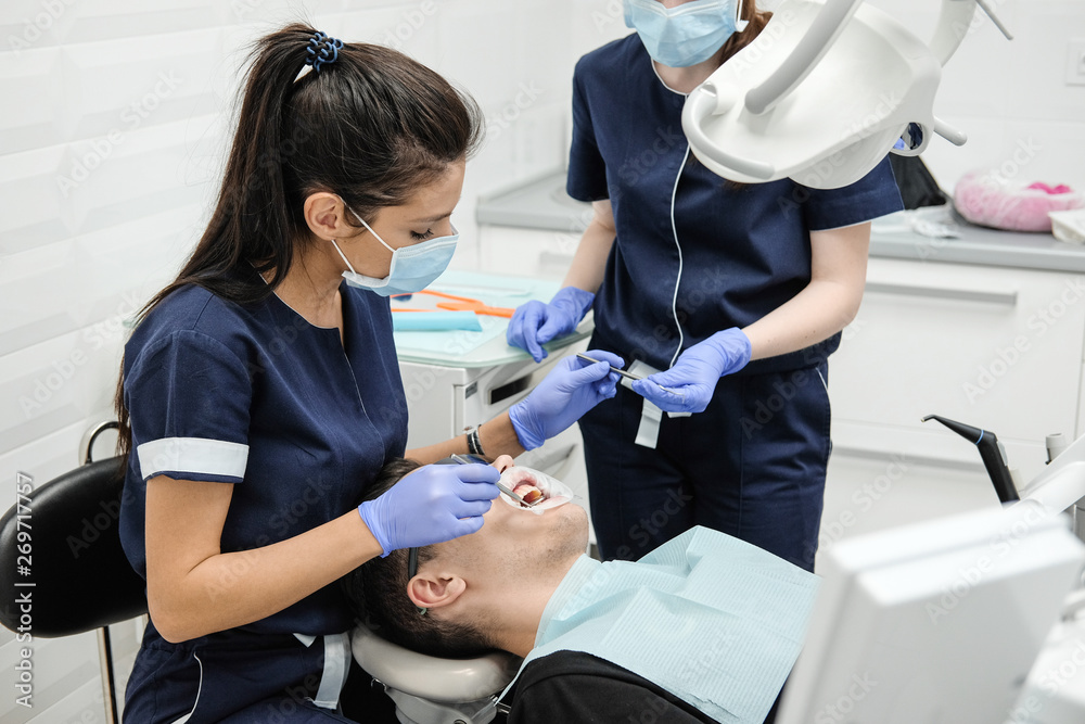 Patient on reception at the dentist. Woman's doctor sets up equipment before dental treatment. Patient on reception at the dentist. Woman's doctor sets up equipment before dental treatment.