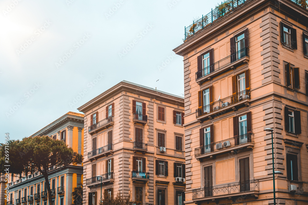 two apartment buildings with pine tree on the left