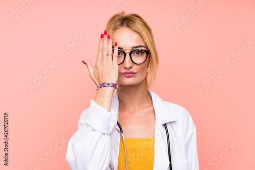 Young blonde doctor woman covering a eye by hand