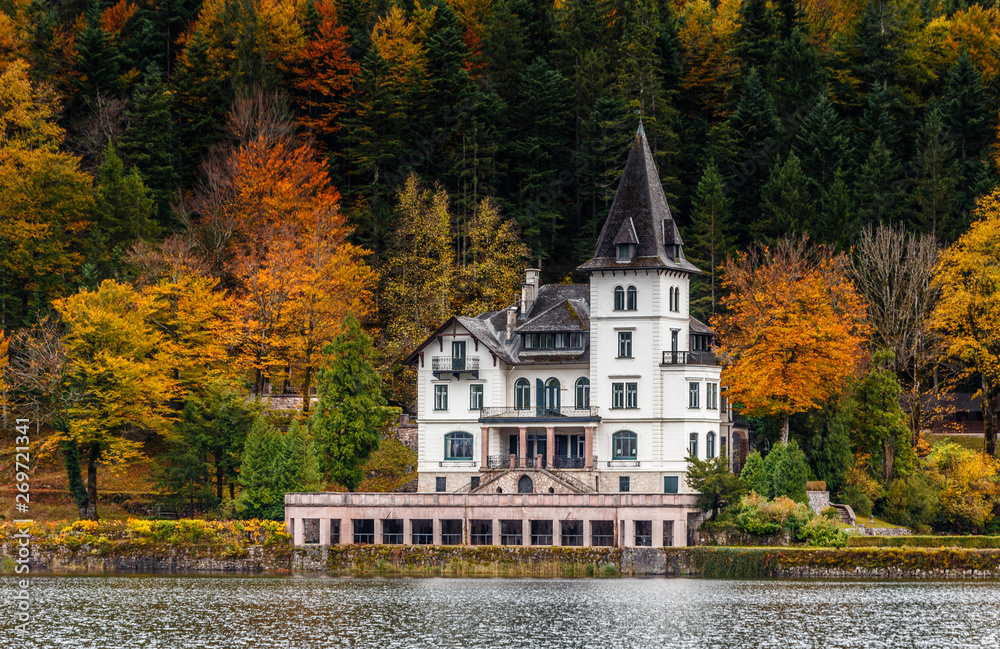 Famous schloss lake Grundlsee, Villa Castiglioni in colorful forest reflected in water, Dramatic autumn alpine scenery over lake Grundlsee, Salzkammergut, Styria, Austria. Awesome Austrian landscape