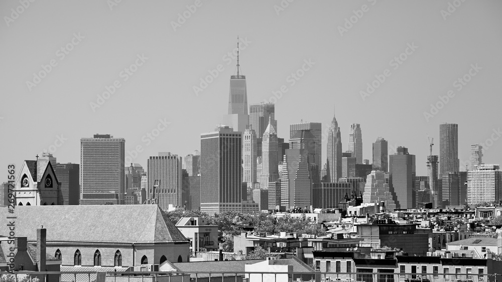 Black and white picture of Manhattan seen from the Brooklyn neighborhood on a hazy summer day, USA.