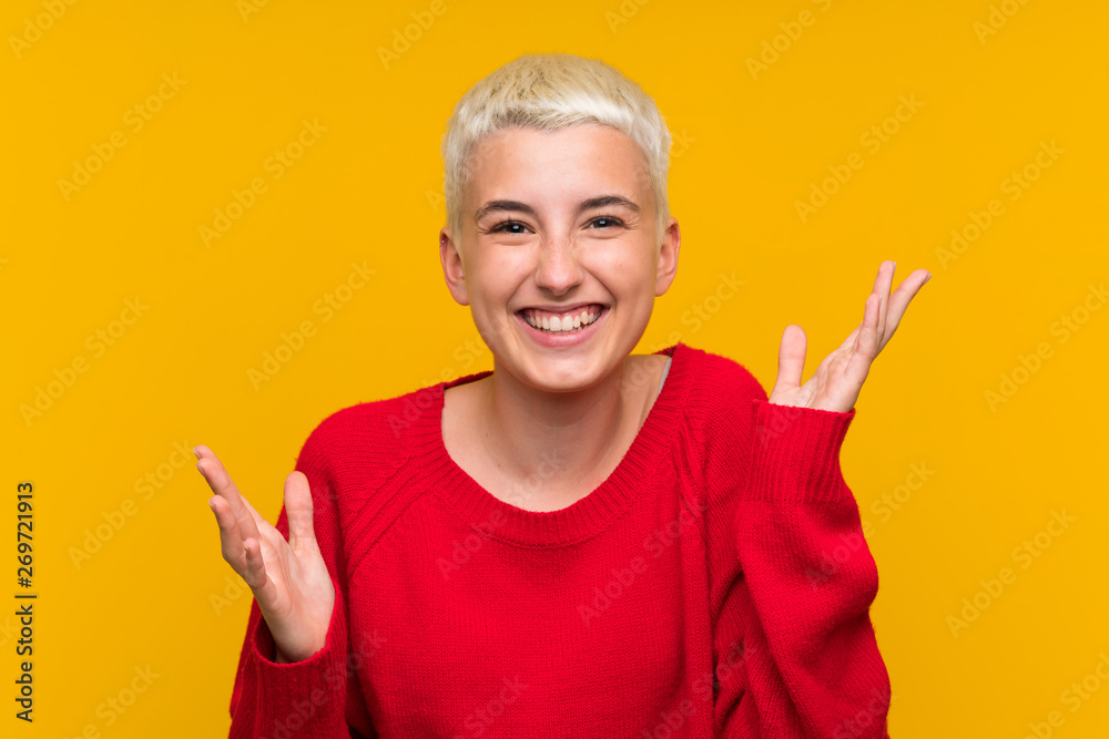 Teenager girl with white short hair over yellow wall laughing Teenager girl with white short hair over yellow wall laughing