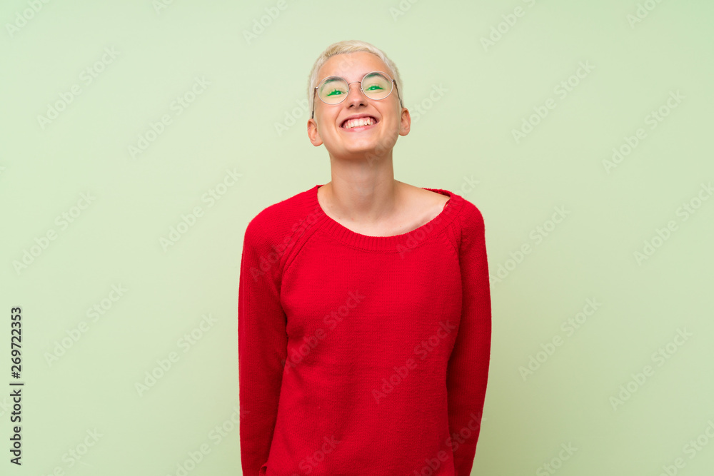 Teenager girl with white short hair over green wall with glasses and happy Teenager girl with white short hair over green wall with glasses and happy