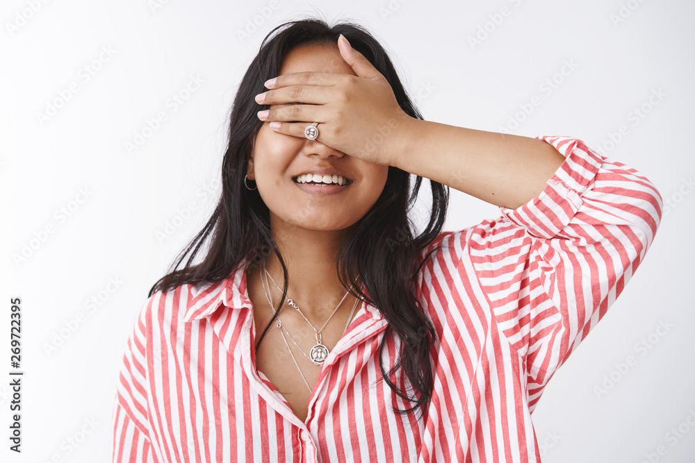 Close-up shot of dreamy attractive young asian girlfriend in striped blouse smiling from anticipation and joy close eyes holding palm on sight as waiting for surprise thrilled over white background Close-up shot of dreamy attractive young asian girlfriend in striped blouse smiling from anticipation and joy close eyes holding palm on sight as waiting for surprise thrilled over white background