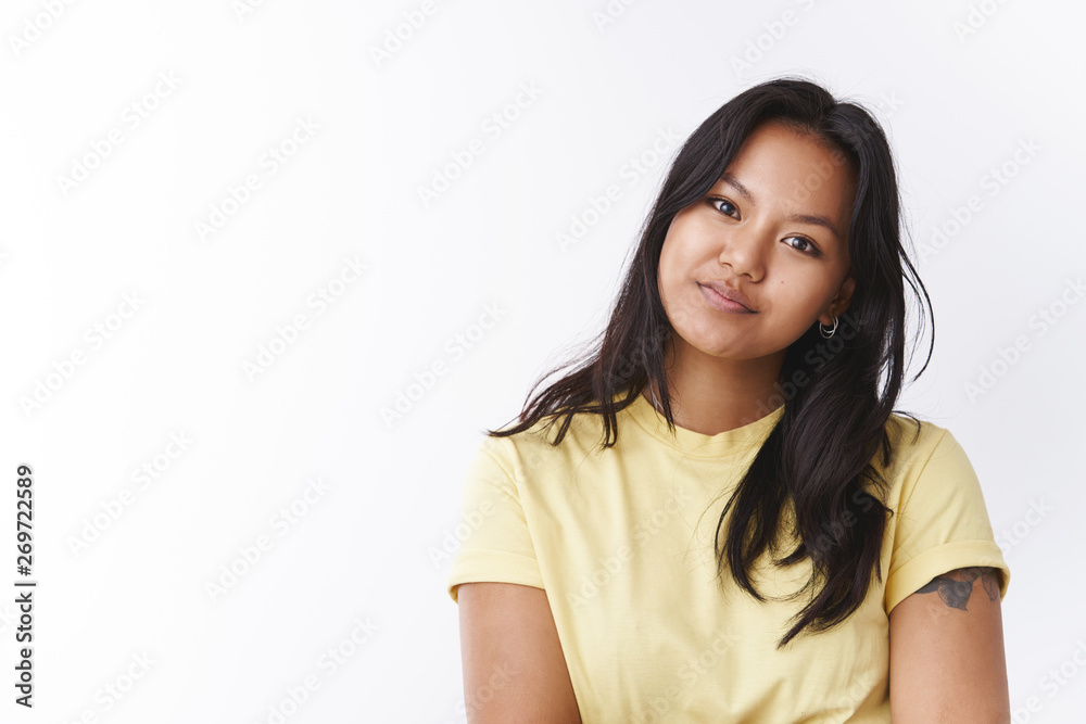 Studio shot of dreamy gentle young attractive asian female in yellow t-shirt tiltintg head tender and gazing at camera, grinning happily and lovely with romantic look over white wall. Studio shot of dreamy gentle young attractive asian female in yellow t-shirt tiltintg head tender and gazing at camera, grinning happily and lovely with romantic look over white wall.