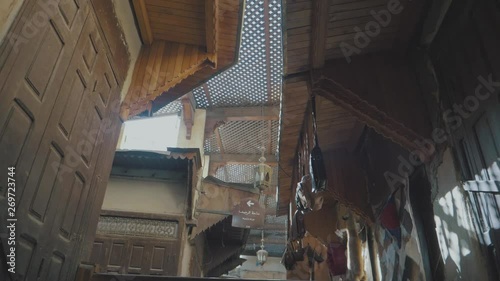 Panning around an outdoor market place in Marrakesh Souk Morocco past decorated stalls and people selling a variety of colorful items in a narrow alleyway