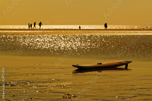 Surfboard on the beach at golden hour sunset