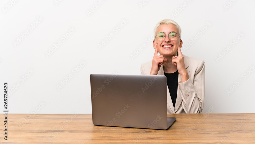 Teenager girl with short hair with a laptop smiling with a happy and pleasant expression Teenager girl with short hair with a laptop smiling with a happy and pleasant expression