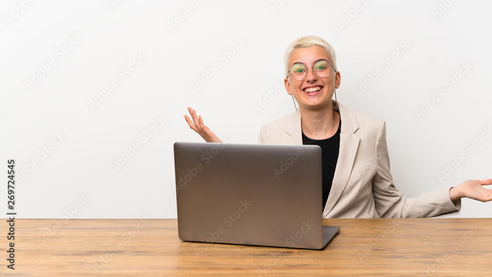Teenager girl with short hair with a laptop smiling