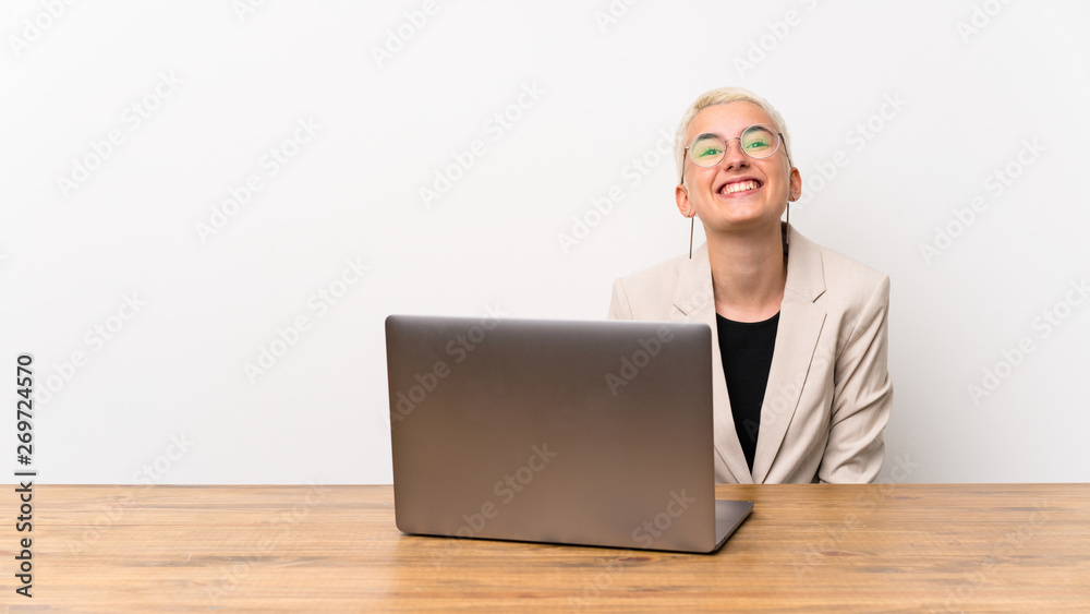 Teenager girl with short hair with a laptop with glasses and happy Teenager girl with short hair with a laptop with glasses and happy