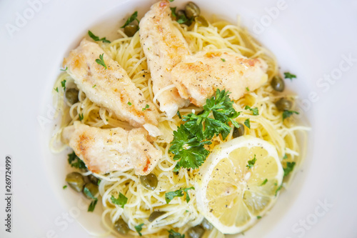 Battered salmon fish fillet dinner with noodles on a plate